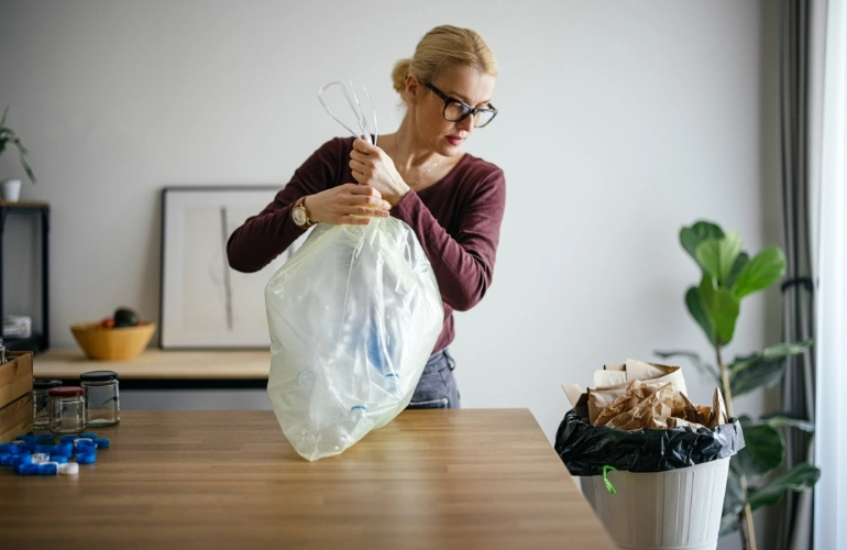 kobieta wyrzucająca śmieci